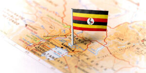 The flag of Uganda pinned on the map. Horizontal orientation. Macro photography.