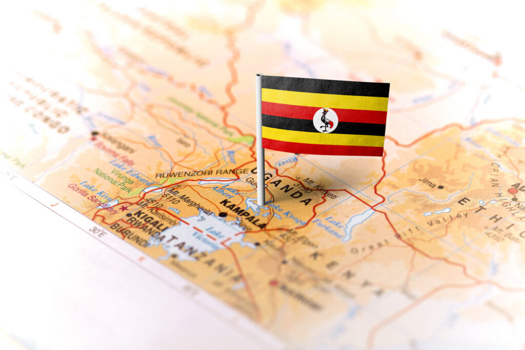 The flag of Uganda pinned on the map. Horizontal orientation. Macro photography.